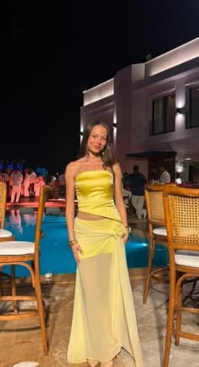 Lemon satin strapless top with a sheer chiffon wrap skirt and rosette, by a pool at night